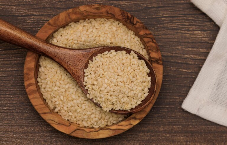 Close-up of a wooden bowl filled with nutritious sesame seeds, perfect for healthy meals.